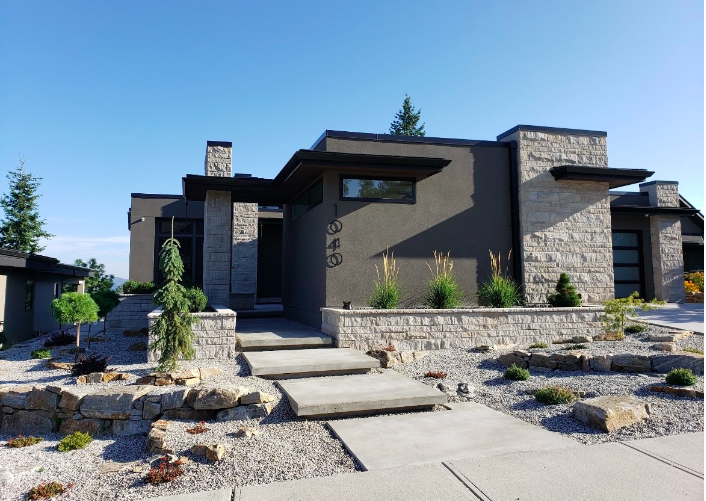 Modern Okanagan home with stonework, landscaping, and a finished exterior