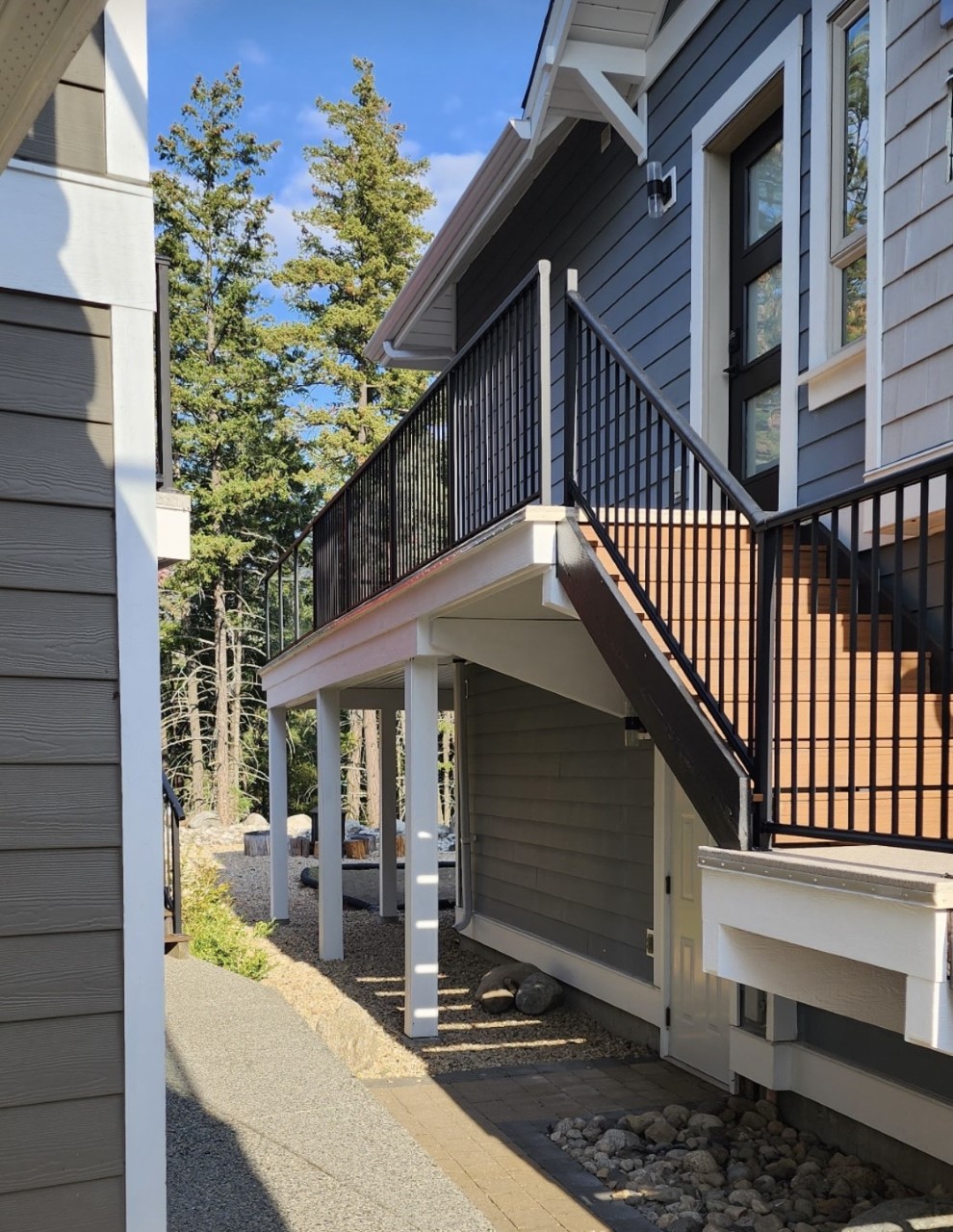 Raised exterior deck with custom black railings and a finished walkway